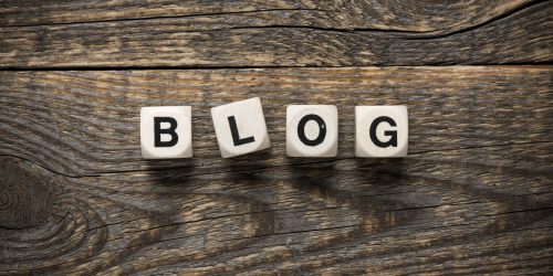 Wooden letter blocks spelling 'BLOG' on a rustic weathered wood surface